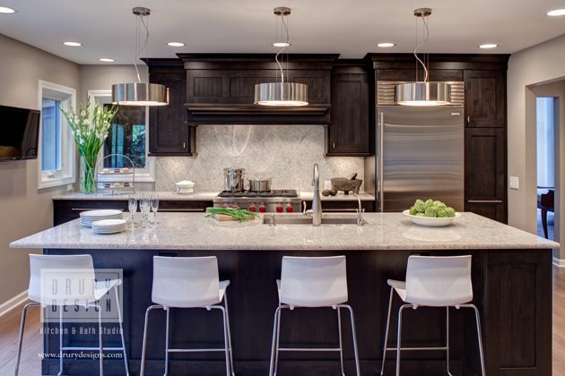 Light colored granite island with seating for four and matching backsplash